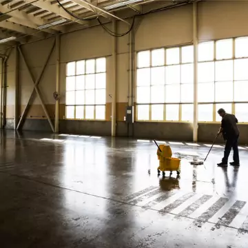 A cleaner is seen mopping an industrial space. Corporate Clean offers industrial cleaning services in Pekin IL.